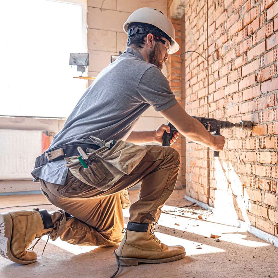 Man drilling hole in wall